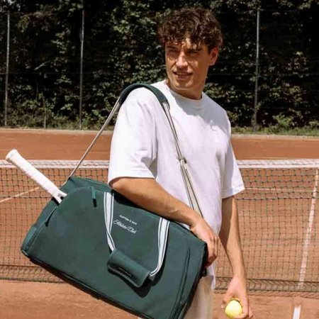 Man loopt over een tennisbaan met een Kapten & Son sporttas