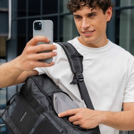 mann trägt kapten son uni rucksack und macht selfie