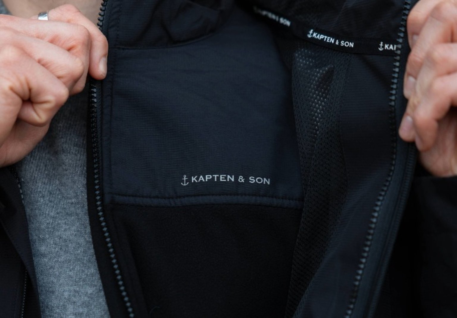 mann enthüllt fleecejacke unter seiner regenjacke