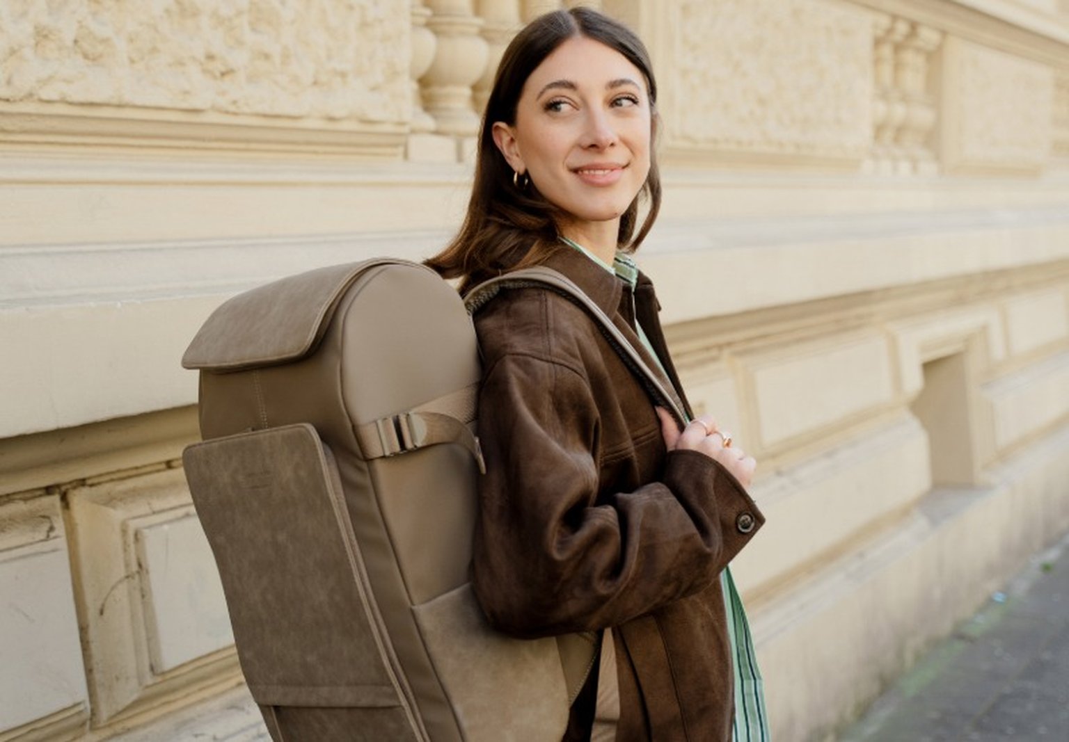 junge frau trägt walnuss farbenen rucksack von kapten and son