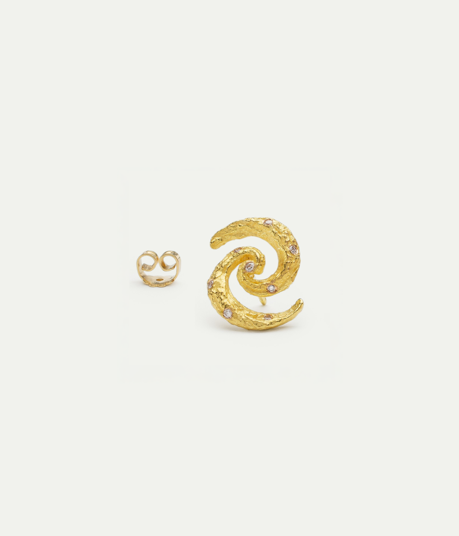 Griegst sculptural gold earring with a spiral silhouette, handcrafted in textured 18k gold and set with diamonds.