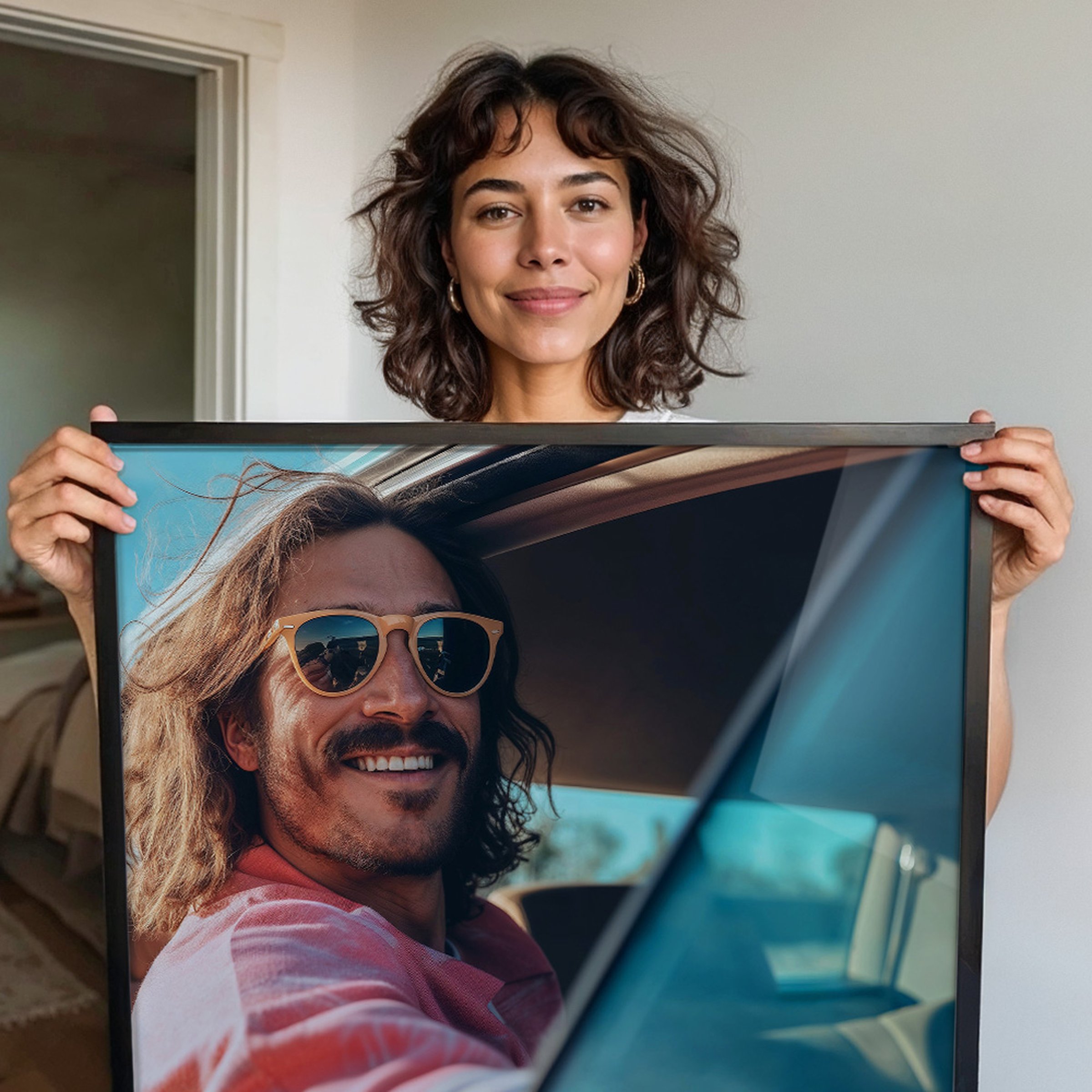Frau mit lockigem Haar hält ein gerahmtes Acrylglasbild eines lächelnden Mannes mit Sonnenbrille vor sich