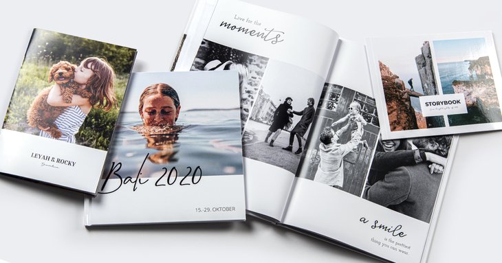 Mehrere Fotobücher in unterschiedlichen Formaten nebeneinander, u. a. mit Cover-Fotos einer Frau mit Hund, einer Schwimmerin und aufgeschlagenen Schwarz-Weiß-Seiten