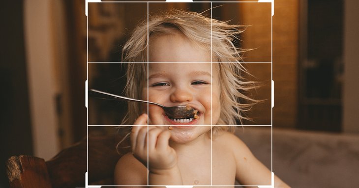 Foto-Zuschnitt-Tool mit Raster über einem Foto eines lachenden Kleinkindes beim Essen mit Löffel