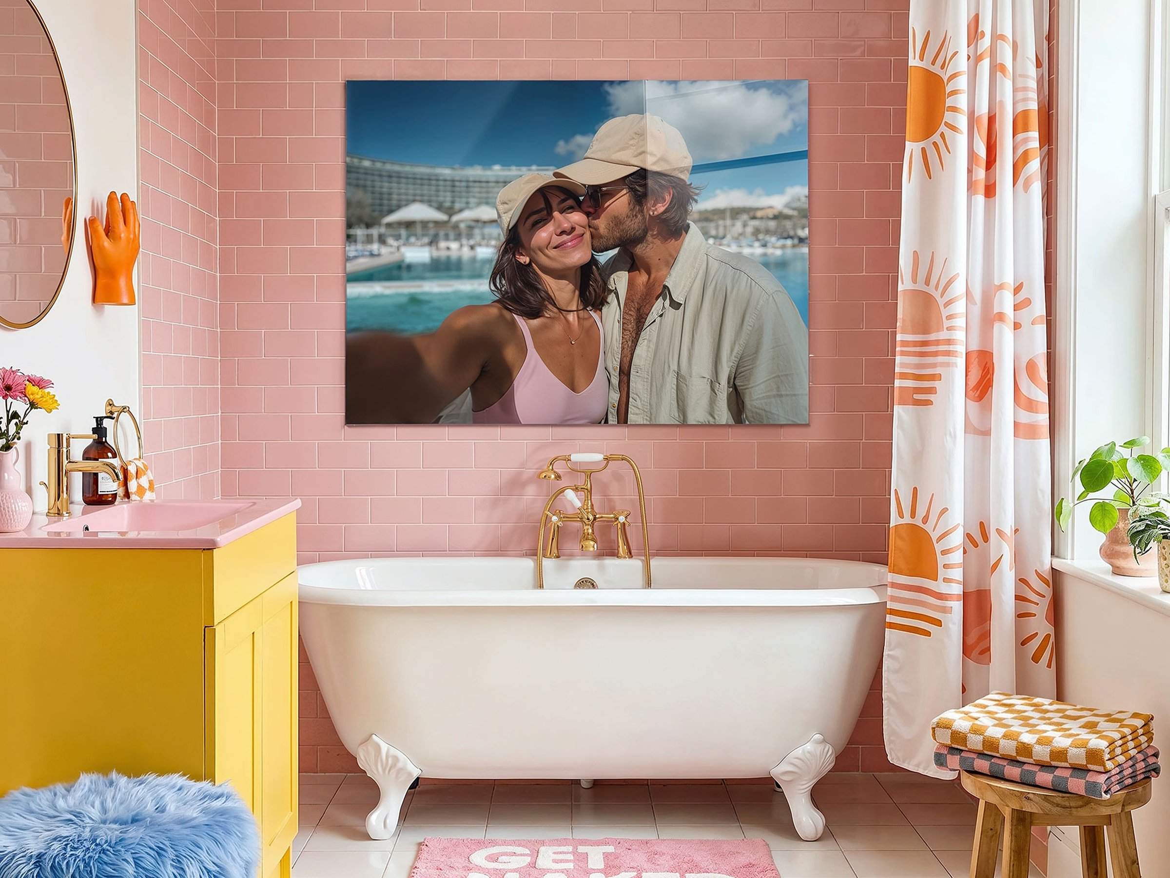 Großformatiges Acrylglasbild eines küssenden Paares am Hafen hängt über der Badewanne in einem rosa gefliesten Badezimmer