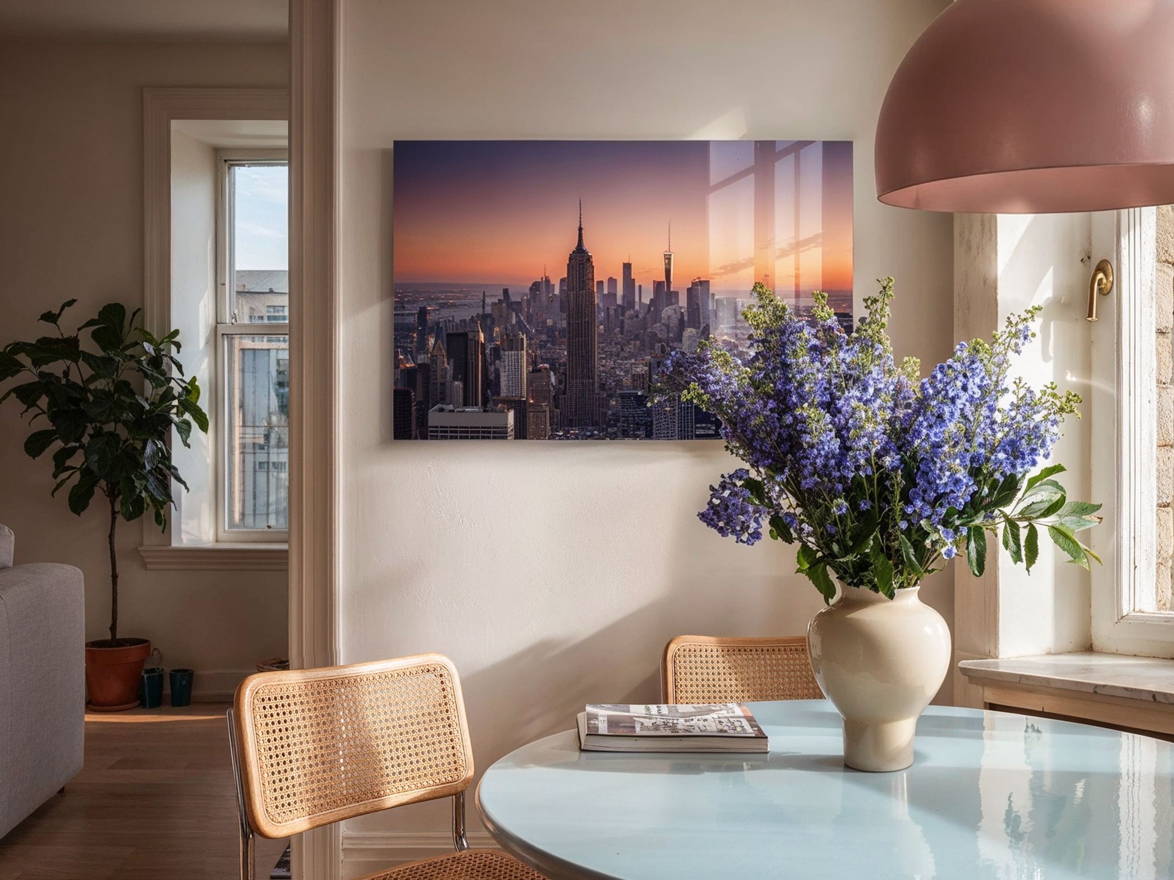 Querformatiges Acrylglasbild einer New Yorker Skyline bei Sonnenuntergang hängt in einem hellen Esszimmer