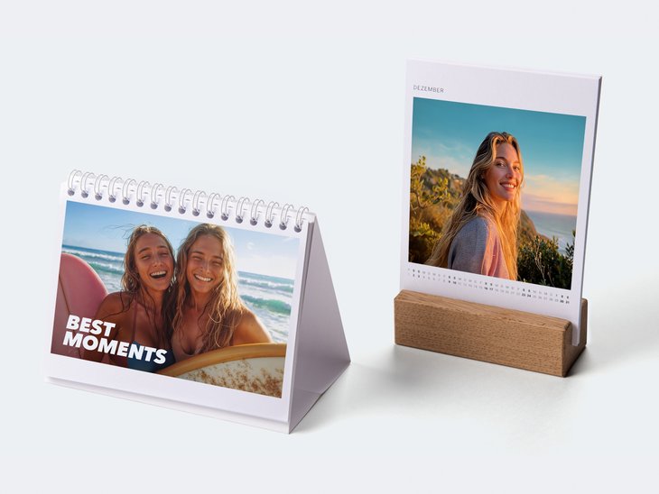 Zwei Tischkalender mit Portrait-Fotos. Der eine ist spiralgebunden, der andere steht in einem Eichen-Holzblock. Der Text lautet „BEST MOMENTS“.