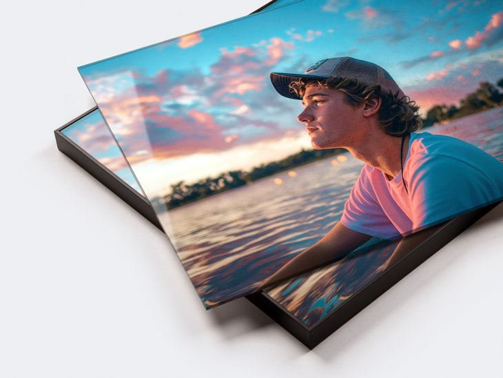 Acrylglasbild mit Porträt eines jungen Mannes vor Wasser und rosa Sonnenuntergangswolken