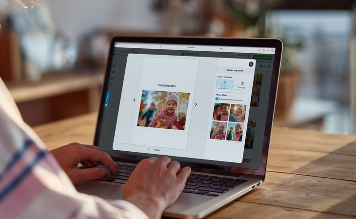 Person passt am Laptop im MYPOSTER-Konfigurator das Cover eines Fotobuchs mit Layout-Varianten und Bildauswahl an