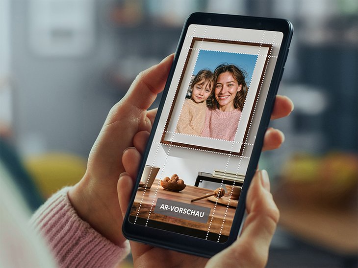 Hände halten ein Smartphone mit dem MYPOSTER Wandbild-Konfigurator