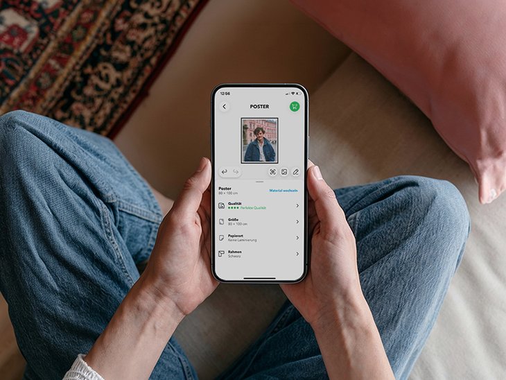 Hände halten ein Smartphone mit der MYPOSTER App
