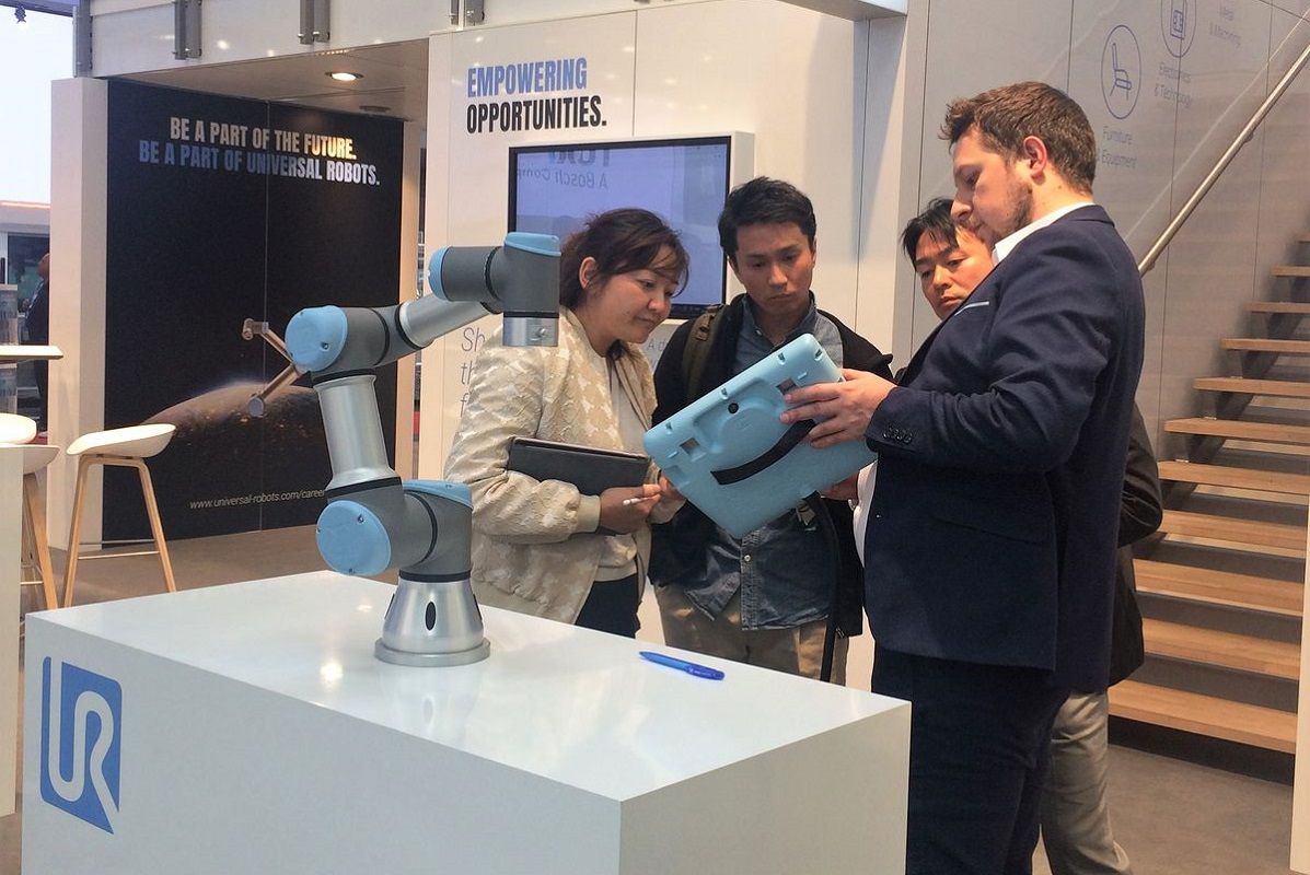 Ein UR Mitarbeiter führt die einfache Programmierung der Roboter vor