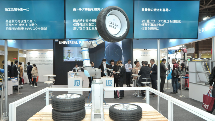 Auf der Tokioter Robotermesse demonstriert ein UR30 Cobot seine beeindruckende Traglast. 