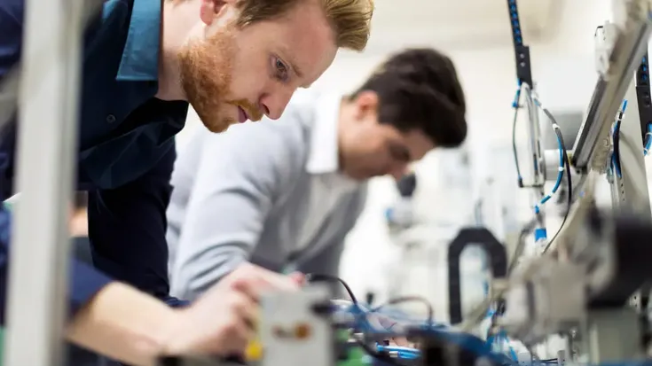 Estudantes em aula prática de robótica educacional trabalhando com equipamentos eletrônicos