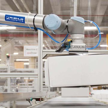 在德國的Rhenus Logistics，一部UR10從托盤上拾取箱子，並放在傳送帶上送往貼標機。UR10 能處理多種不同尺寸和重量的箱子。