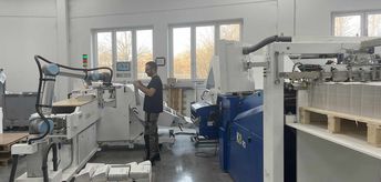 ドイツのGeiselberger社はUR10協働ロボットを導入し、機械稼働率100％を実現しました。MBO Postpress Solutions社（以下、MBO）のシステムCobo-Stackが折った印刷物をUR10がパレタイズしています。