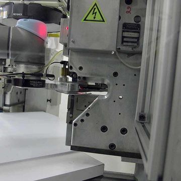 The Arizona company programmed its first UR5 to pick up pre-cut fabric material that the cobot moves through a snap-set machine where five male snaps are inserted, then it moves over to a second machine where five female snaps are added.