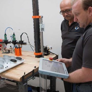 Einar Rosenberg, CEO of Creating Revolutions, with a UR3 robot handling the assembly of a service pager for the hospitality industry