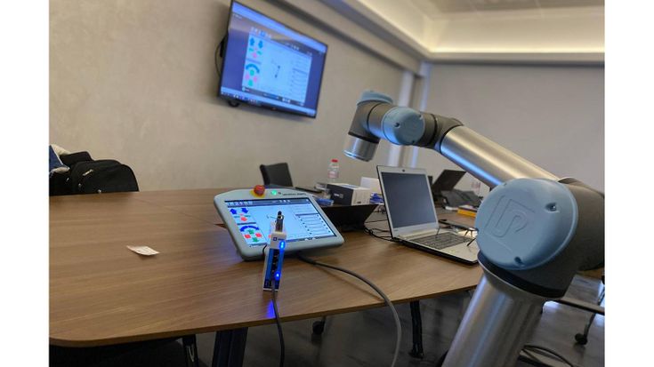 IXON的遠端存取平台包含IXrouter(foreground on desk)以及URCap軟體,其將協作型機器人及教導器連結至網路平台。