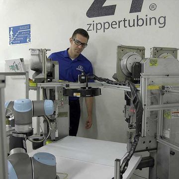 Zippertubing installed an area scanner making the robot slow down as soon as a person enters the work envelope.