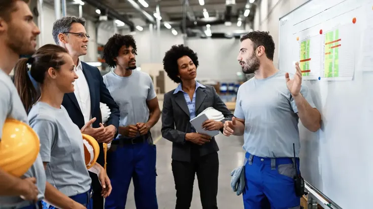 Profesionales revisando indicadores y herramientas de calidad en proceso de producción industrial