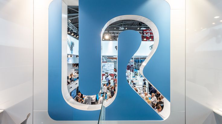 Skilled technician performing precision glasswork with a flame torch, highlighting craftsmanship and innovation supported by the UR+ ecosystem and certified partner solutions.