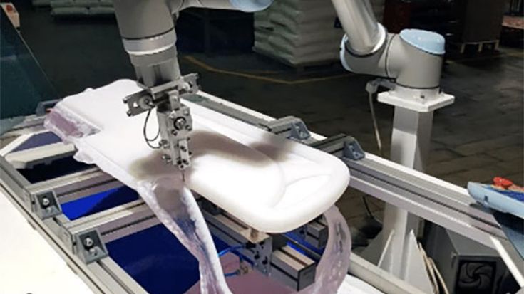Een UR-cobot snijdt een geblaasvormd onderdeel voor een ziekenhuisbed.