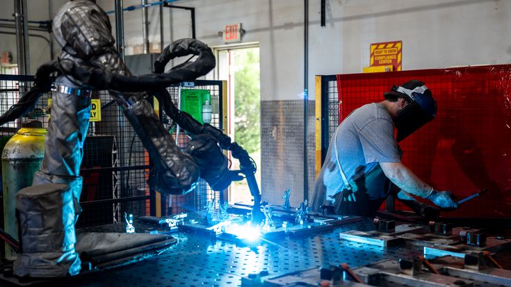Robot welding brackets next to welder