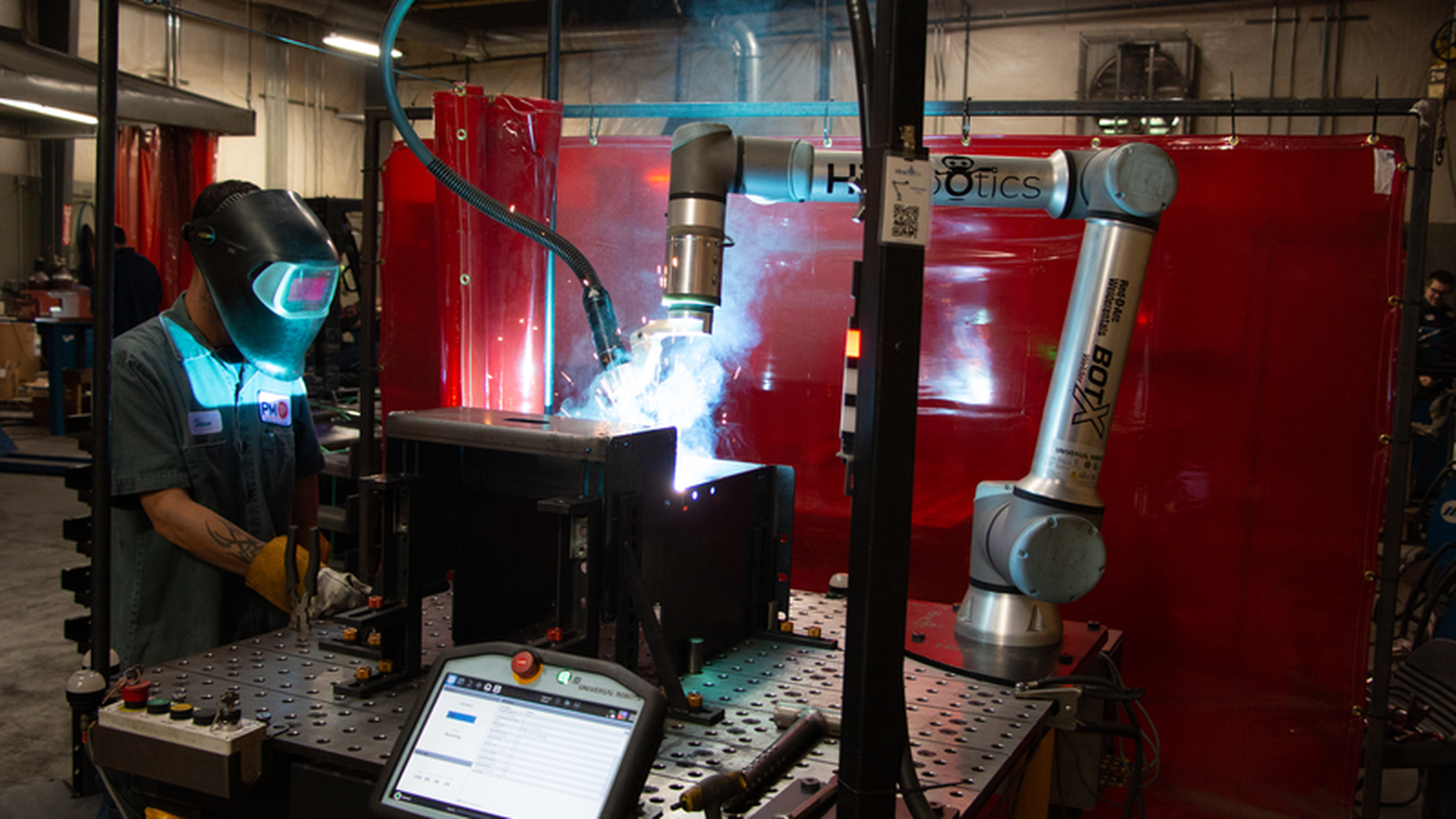 Collaborative robot welding a metal fabrication assembly