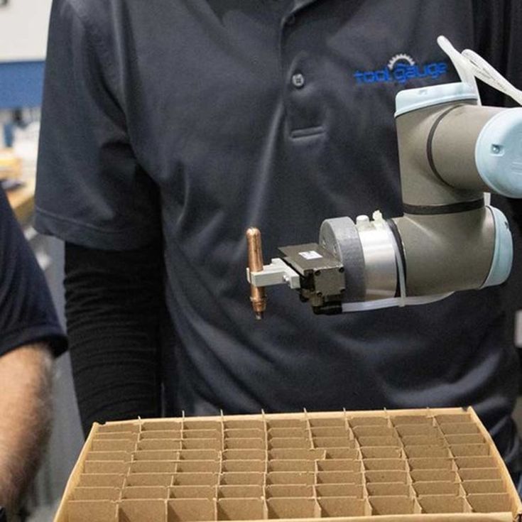 Bij Tool Gauge gebruikt de UR3 de ingebouwde palletiseer-assistent om onderdelen zorgvuldig in het raster te plaatsen