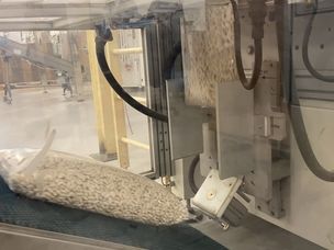 Le sac rempli de sauce se déplace le long d'un convoyeur, est étiqueté et son poids est vérifié