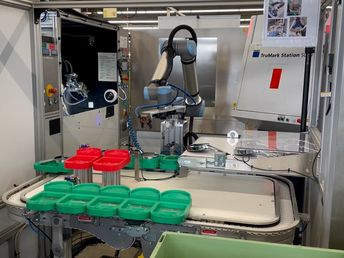 Der cobot holt den vom Bediener auf dem Förderband platzierten Duschkopf