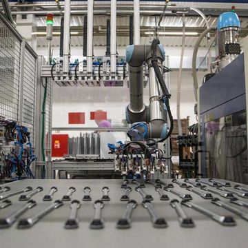 Na 2K Trend, empresa tcheca, um cobot UR10 pega partes para inserir em um molde de injeção plástica.