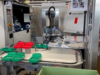 Er legt es auf ein zweites Förderband zum Verpacken