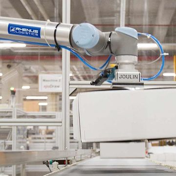 Bij Rhenus Logistics in Duitsland pakt een UR10 dozen op van een pallet en plaatst ze op een transportband die de dozen naar een etiketteermachine brengt. De UR10 kan dozen van vele verschillende afmetingen en gewichten verwerken.