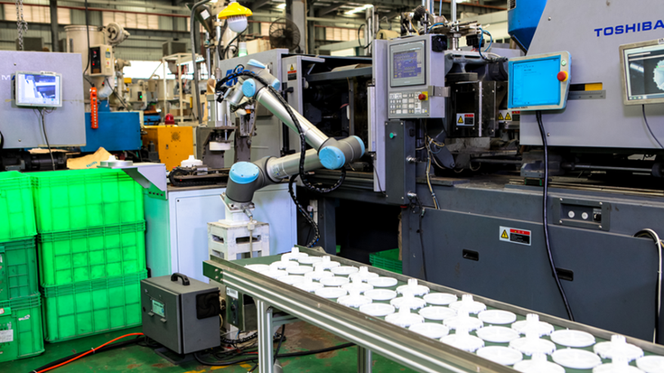 Robot cộng tác đang thực hiện nhiệm vụ tại một xưởng ép nhựa.