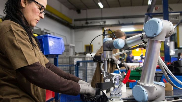 Roboter und Mensch arbeiten Seite an Seite.