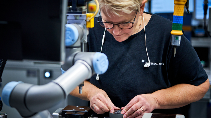 Hand in Hand arbeiten Mensch und Cobot auch in unserer eigenen Produktion in Dänemark zusammen.