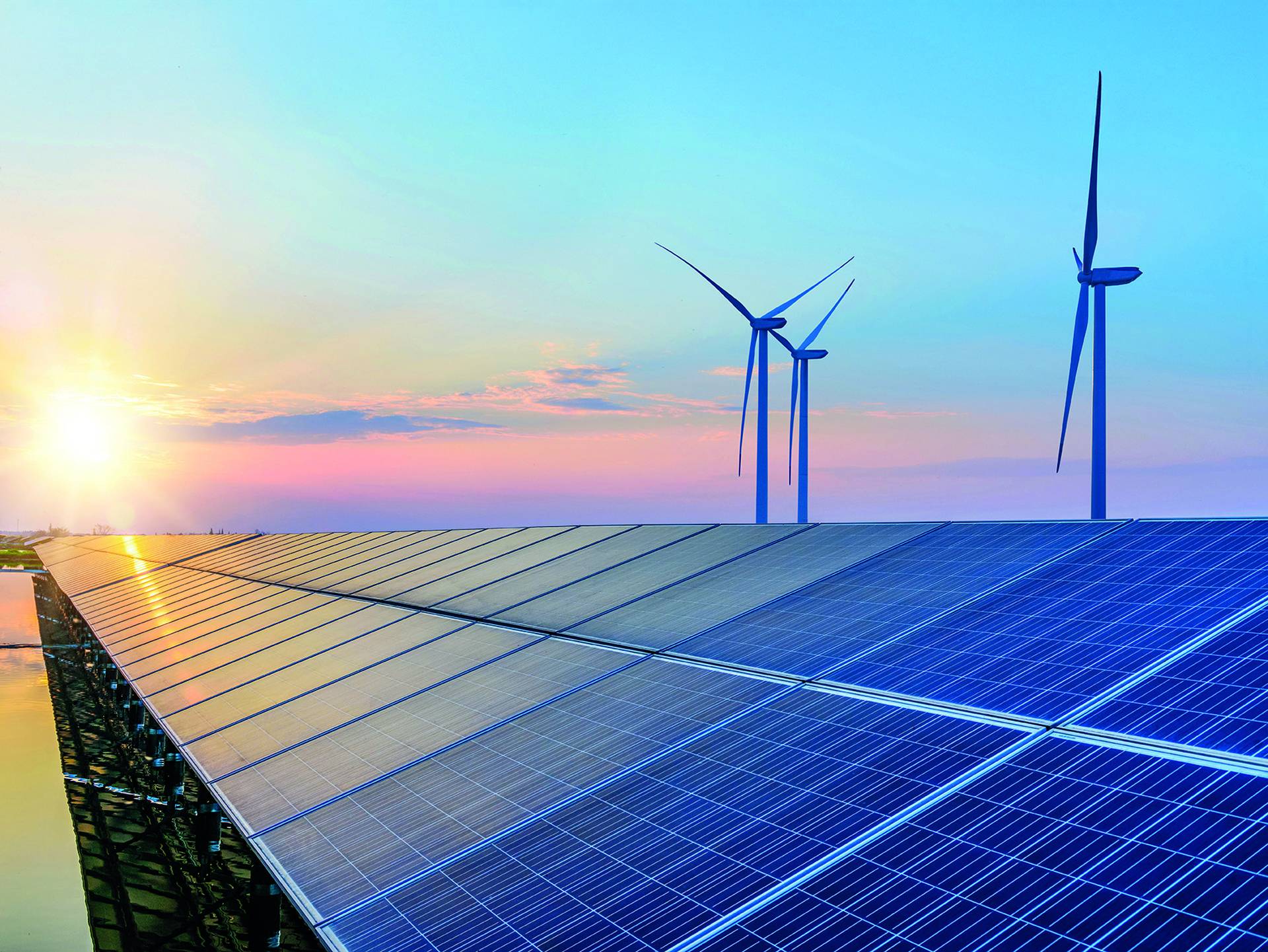 Solar panels and wind turbines under a vibrant sunset sky, reflecting renewable energy technology in a serene landscape.