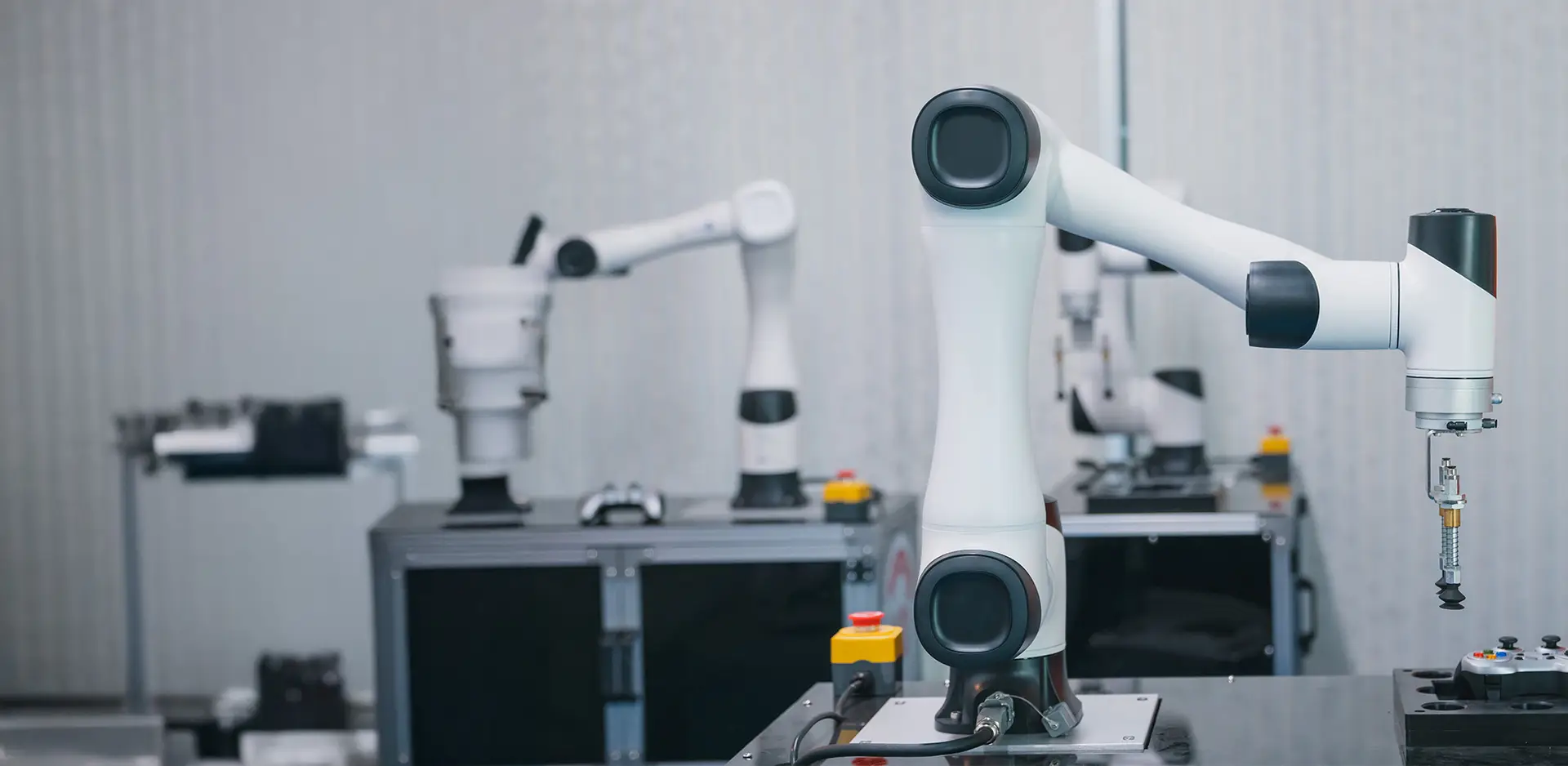 Industrial robot arms in an automated production environment, equipped with precise grippers, on a stable table.