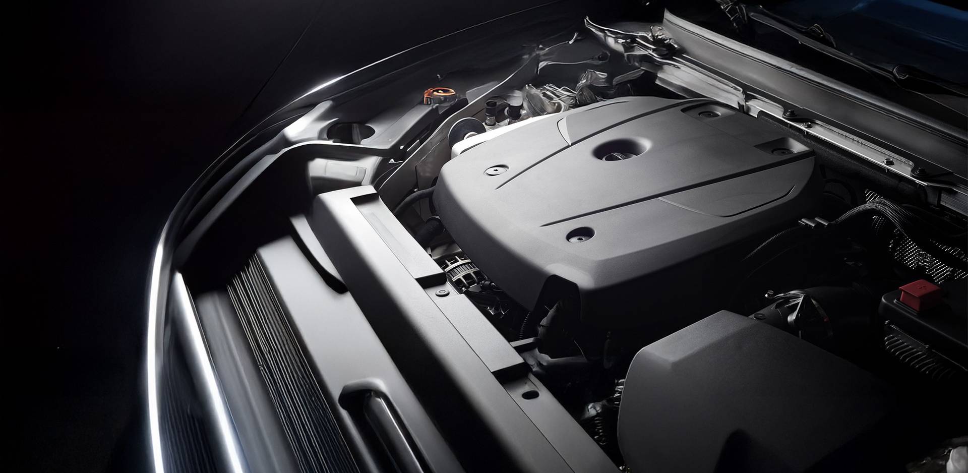 Detailed view of a modern car engine with cover, shown in a coordinated professional light