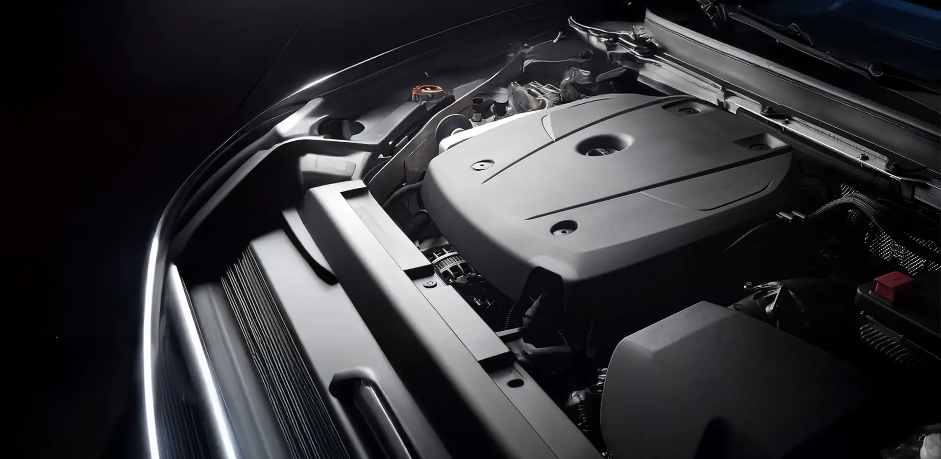 Detailed view of a modern car engine with cover, shown in a coordinated professional light