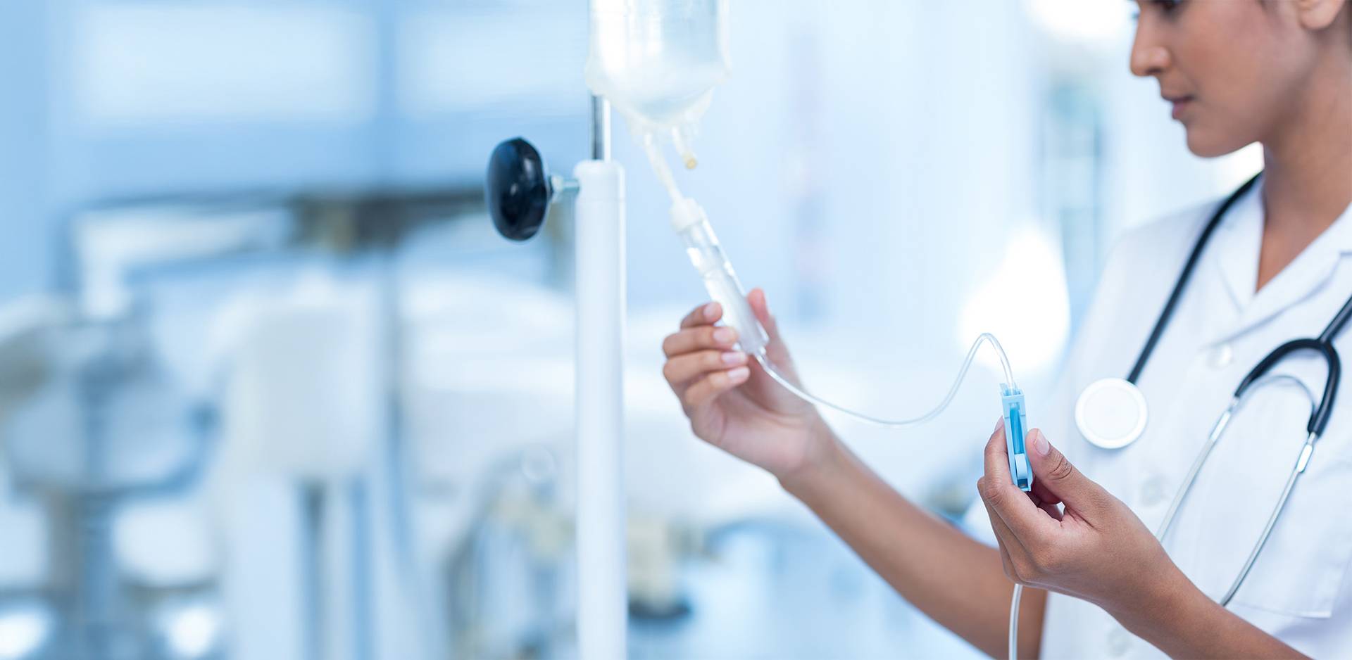 Medical staff preparing an intravenous drip in a modern, light-filled clinic.