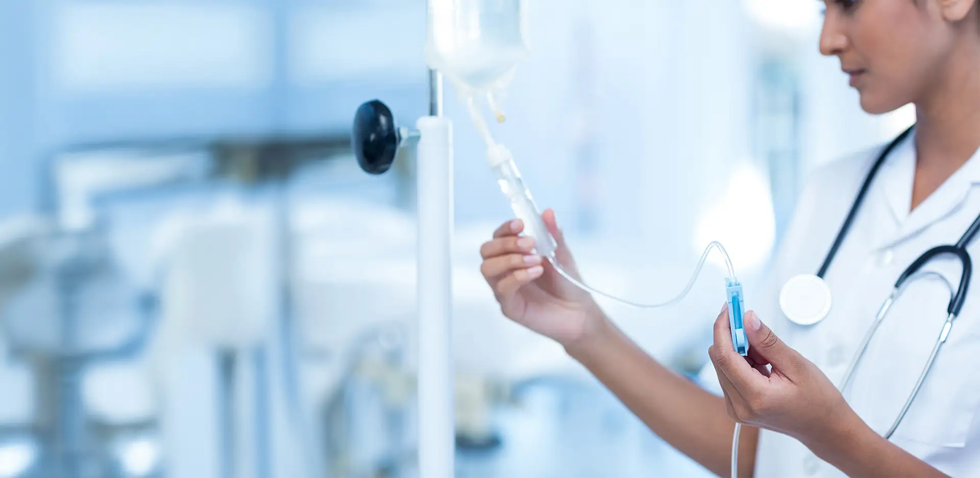 Medical staff preparing an intravenous drip in a modern, light-filled clinic.