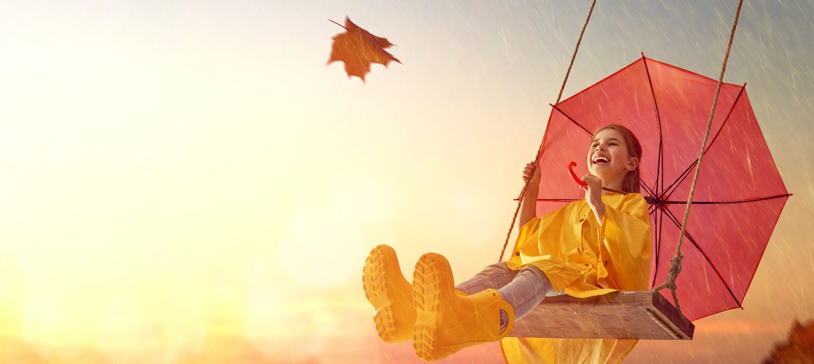 girl in rain coat on a swing