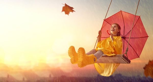 girl in rain coat on a swing