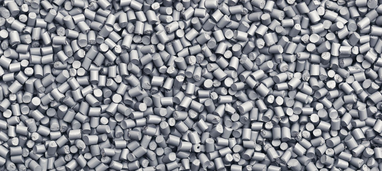 Close-up of numerous  gray plastic pellets densely packed together.