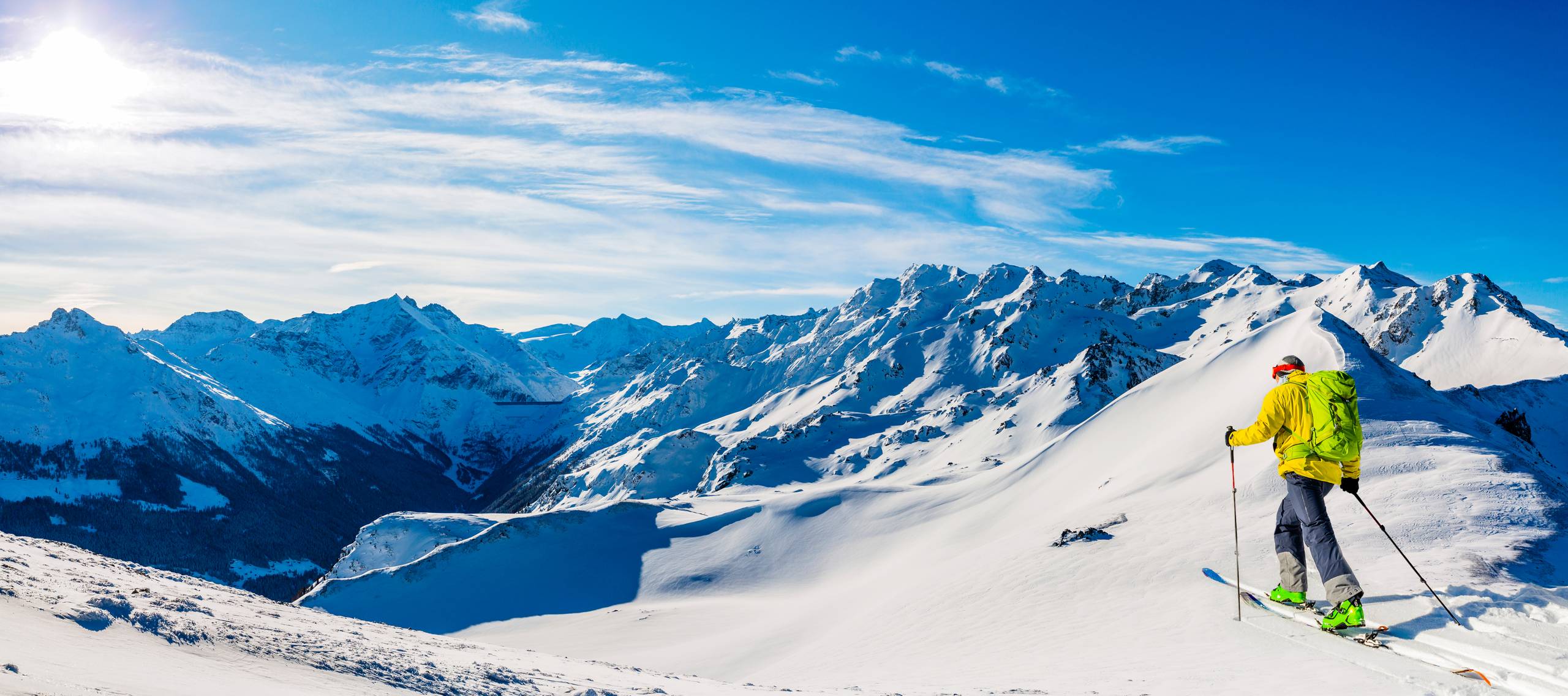 Ski tour in alpine landscape with bright sun