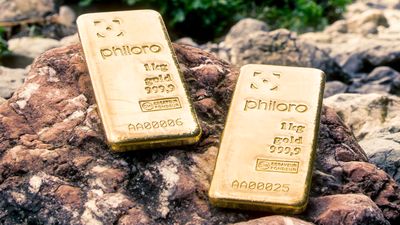 Zwei Goldbarren von philoro auf einem Felsen.