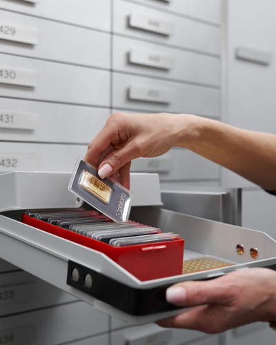 Schliessfach Eine Frau die gerade etwas aus ihrem Schliessfach heraus nimmt.